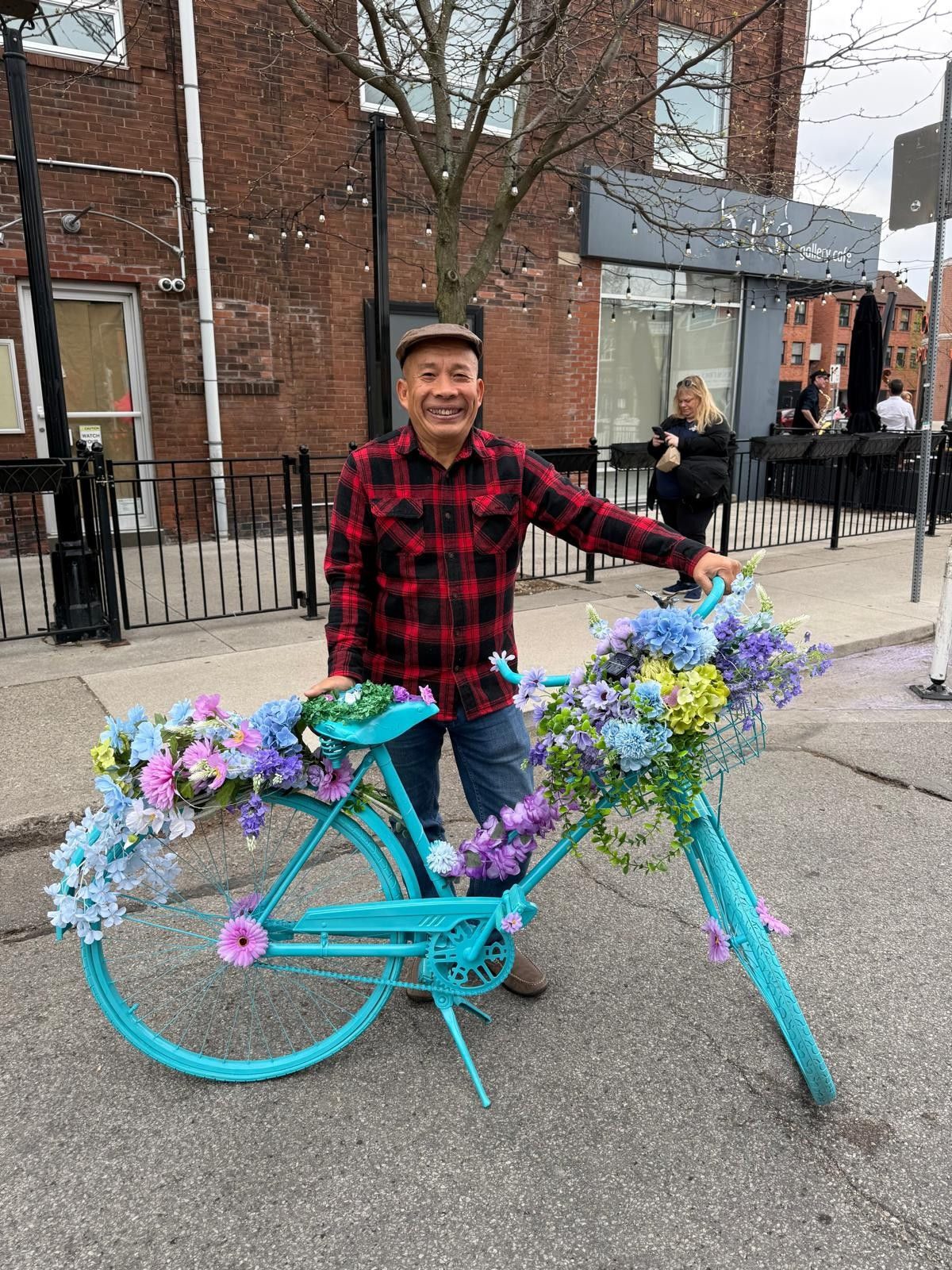 Adam Pham with a flower-decorated bicycle on a Toronto street